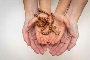 two hands with rosary
